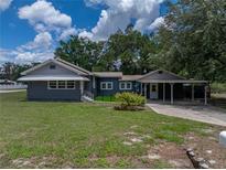 Charming single-story home with a lush green lawn and a covered parking area at 803 7Th Ne St, Fort Meade, FL 33841