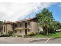 Two-story home featuring a stone facade, a balcony, and ample parking space at 817 Orchid Springs Dr, Winter Haven, FL 33884
