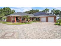 Stunning single-story home featuring a beautifully paved circular driveway, solar panels, and a two-car garage at 9950 W Lake Marion Rd, Haines City, FL 33844
