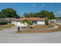 Charming single-story home with a well-maintained lawn and a two-car garage at 1055 Sunshine Sw Way, Winter Haven, FL 33880