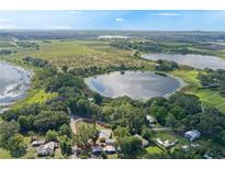 An aerial view of property with surrounding trees, bodies of water and open land at 1163 Lake Dr, Lake Wales, FL 33859