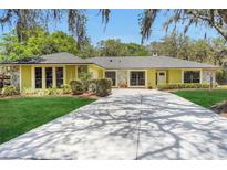 Charming single-story home with a long driveway, stone accents, manicured lawn and mature landscaping at 1226 Lake Loop, Winter Haven, FL 33880