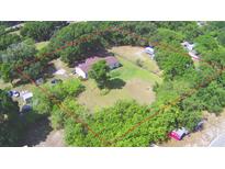 Expansive aerial view of a wooded lot with mature trees and single-Gathering home and outlined with a red boundary line at 1294 1/2 38Th Nw St, Winter Haven, FL 33881