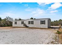 Charming one-story home featuring gray siding, black shutters, and a well-maintained front yard at 1499 32Nd Nw St, Winter Haven, FL 33881