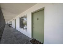 Inviting front door entrance with a welcoming mat on an open air corridor at 1700 6Th Nw St # C26, Winter Haven, FL 33881