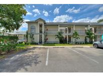 Exterior view of a condominium building with parking and palm trees at 2180 San Marcos Se Cir # 401, Winter Haven, FL 33880
