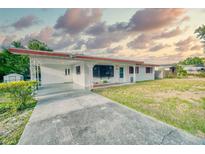 Charming single-story home featuring a covered carport and a well-maintained front lawn at 230 W Harbord St, Lake Alfred, FL 33850