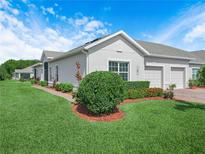 Charming villa featuring a well-manicured lawn and beautiful landscaping at 2824 Attwater Loop, Winter Haven, FL 33884