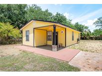 Charming yellow home featuring a cozy front porch and well-maintained landscaping at 305 Armour Ave, Auburndale, FL 33823
