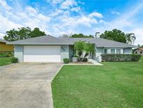 Charming single-story home featuring a well-manicured lawn and an attached two-car garage at 409 N 6Th St, Lake Hamilton, FL 33851