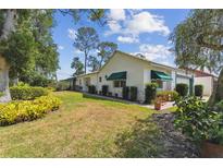 Charming single-story home with a well-manicured lawn, green awnings, and mature trees at 441 San Jose Dr, Winter Haven, FL 33884