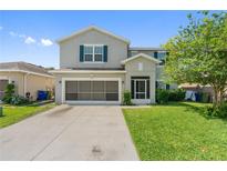Front exterior featuring a two car garage with landscaping at 476 Haines Trl, Winter Haven, FL 33881