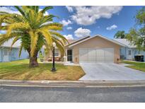 Charming single-story home with a well-manicured lawn and a two-car garage at 492 Sweetwater Way, Haines City, FL 33844