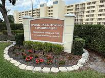 An inviting Spring Lake Towers Condominium welcome sign with beautiful flowers at 700 Mirror Nw Ter # 303, Winter Haven, FL 33881