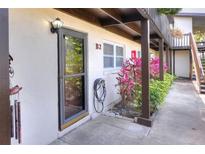 Exterior view of the home featuring the front door, beige walls, and dark brown accents at 900 Avenue Z Se # B2, Winter Haven, FL 33880