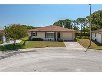 Charming single-story home features a well-manicured lawn, attached garage, and welcoming walkway at 3245 Prairie Dunes E Cir, Lakeland, FL 33810
