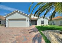 Charming single-story home featuring an attached garage, well-manicured lawn, and beautiful landscaping at 4175 Muirfield Loop, Lake Wales, FL 33859