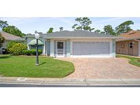 Charming single-story home featuring a brick driveway and manicured lawn at 469 Sweetwater Way, Haines City, FL 33844
