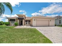 Charming single-story home with a well-manicured lawn, front fountain, and brick-paved driveway leading to an attached two-car garage at 5005 Pebble Beach Blvd, Winter Haven, FL 33884