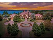 Stunning waterfront home boasts mature landscaping and a circular driveway with center water feature at 501 Adams Barn Rd, Auburndale, FL 33823