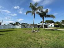 Charming single-story home featuring lush green lawn, two palm trees, and a covered carport on a sunny day at 502 Canal Dr, Lake Wales, FL 33859