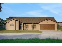 Well-maintained single-Gathering home showcasing a tidy front yard and an attached two-car garage at 505 8Th S St, Dundee, FL 33838