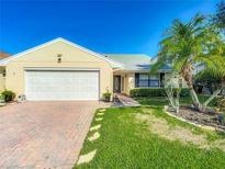 Charming single-story home featuring a well-maintained lawn, brick driveway, and an attached two-car garage at 560 Saint Andrews Rd, Winter Haven, FL 33884