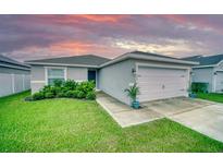 Charming single-story home with a well-manicured lawn and attached two-car garage at 648 Lorient Dr, Eagle Lake, FL 33839