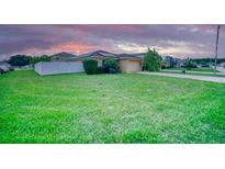 Well-maintained single-story home featuring a spacious green lawn and a white picket fence at 713 Overlook Grove Dr, Winter Haven, FL 33884