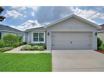 Charming single-story home with a well-maintained lawn and beautiful landscaping at 879 Orleans Dr, Eagle Lake, FL 33839