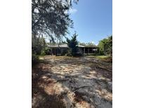 Single story home featuring a screened porch and a spacious, sandy front yard at 900 Hwy 630 E, Frostproof, FL 33843