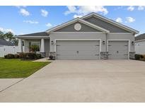 Charming home featuring a two-car garage, stone accents and lush landscaping at 1081 Sandpiper Loop, Winter Haven, FL 33881