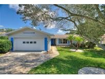Charming single-story home featuring a well-manicured lawn, mature trees, and a two-car garage at 118 Browning Cir, Winter Haven, FL 33884