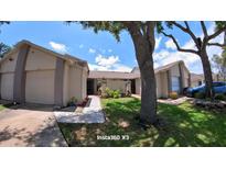 Inviting townhome exterior featuring a well-maintained lawn and serene landscaping at 12241 Augusta Woods Cir, Orlando, FL 32824