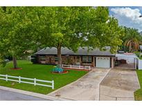 Charming single-story home with a vibrant green lawn, mature trees, and a cute turquoise bicycle decoration at 1491 Avenue F Ne, Winter Haven, FL 33881