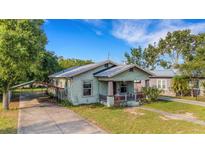 Charming home with a quaint front porch, covered parking, and a well-maintained lawn at 165 E Pierce St, Lake Alfred, FL 33850
