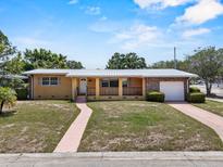 Charming single-story home featuring a brick accent wall, a covered porch, and a well-maintained front yard at 1929 4Th Ne St, Winter Haven, FL 33881