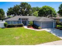 Charming single-story home with a well-manicured lawn, tidy landscaping, and a two-car garage at 2240 Country Manor St, Bartow, FL 33830