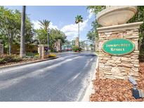 Towncenter Resort entrance with stone gate, lush landscaping, and black iron fence create an inviting atmosphere at 263 Reserve Dr, Davenport, FL 33896