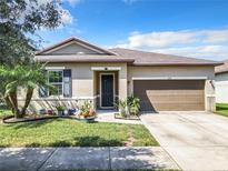 Charming single-story home with a well-maintained lawn, landscaping, and a two-car garage at 278 Alford Dr, Davenport, FL 33896
