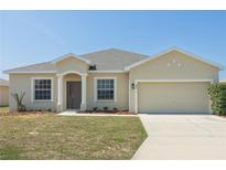 Charming single-story home with a neutral-colored exterior, a well-manicured lawn, and an attached two-car garage at 327 Cloverdale Rd, Winter Haven, FL 33884