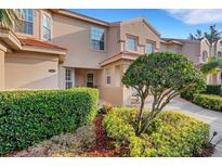 Inviting townhome exterior with manicured landscaping and a charming entrance, set under a bright blue sky at 351 Enclave Dr # 94, Lakeland, FL 33803