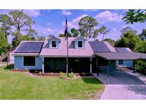 Charming single-Gathering home featuring a covered carport, solar panels, and a well-manicured lawn at 3705 Pine Cir, Lake Wales, FL 33898