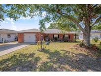 Charming brick home with a well-manicured front yard and mature shade trees, offering curb appeal at 40 Westridge Rd, Davenport, FL 33837
