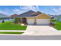 Charming single-story home with a two-car garage, well-manicured lawn, and delightful landscaping at 421 Riders Loop, Auburndale, FL 33823
