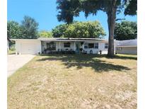 Charming single-story home with a well-kept lawn and a pop of color from the bright blue front door at 550 E Thelma St, Lake Alfred, FL 33850