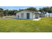 Inviting single story home with blue door, grassy lawn and waterfront views at 8314 W Lake Marion Rd, Haines City, FL 33844