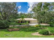 Charming home with metal roof, stone accents, lush landscaping, and inviting curb appeal, creating a serene setting at 1273 Scrub Jay Trl, Frostproof, FL 33843