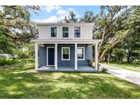 Charming two-story home featuring a blue exterior, white trim, covered porch, and a well-maintained lawn at 2052 W Elliott St, Lakeland, FL 33805