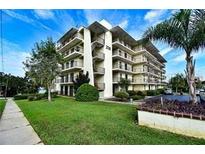 Multi-story condo building with green lawn and meticulous landscaping offers a welcoming curb appeal at 208 Lake Howard Nw Dr # 104, Winter Haven, FL 33880
